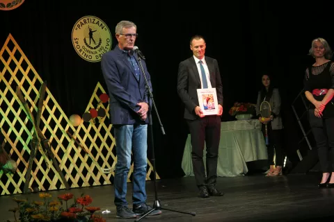 Starosta Sokolske zveze Slovenije Dušan Gerlovič (v ospredju) je ob jubileju predsedniku ŠD Partizan Tomažu Pisku poklonil knjigo Sokoli v filateliji o zgodovini sokolskega gibanja na Slovenskem. / Foto: Mateja Rant