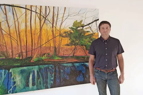 Gregor Pratneker ob svojih barvitih slikah gozdov / Foto: 