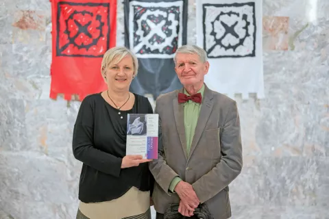 Sedanja urednica zbornika Pasijonski doneski Helena Janežič ter idejni oče in dolgoletni urednik Alojzij Pavel Florjančič z jubilejno izdajo / Foto: Primož Pičulin