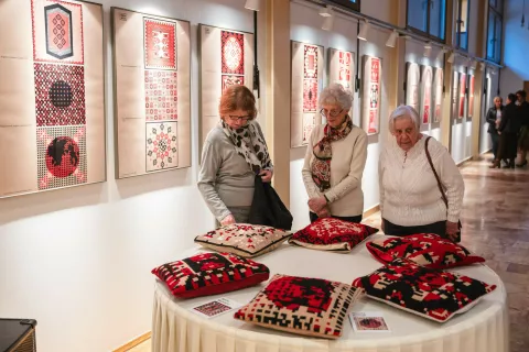 Na ogled so grafični vzorci in blazine, ki so jih na osnovi vzorcev izvezle jeseniške ženske. / Foto: Nik Bertoncelj