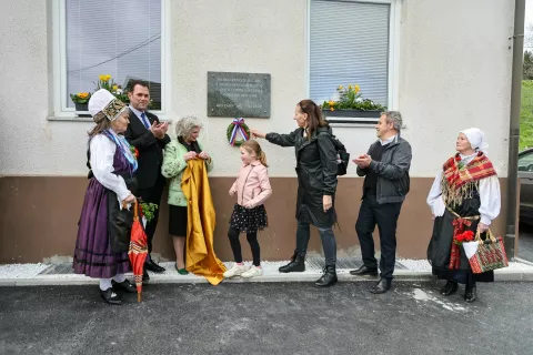 V Zasipu so se nekdanji pesnici in učiteljici Vidi Jeraj poklonili s spominsko ploščo na domu krajanov. / Foto: Tina Dokl