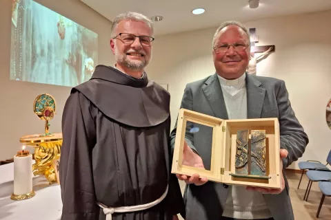 Po pogovoru je rektor svetišča na Brezjah pater dr. Robert Bahčič (levo) gostu iz Fatime dr. Carlosu Cabecinhasu izročil posebno darilo – repliko svetih vrat v brezjanski baziliki. / Foto: Jože Košnjek