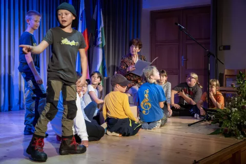 V igranem prizoru so nas v preteklost šolstva v domačem kraju popeljali učenci podružnične šole Jezersko, na odru se jim je pridružila tudi Anica Jakopič. / Foto: Primož Pičulin