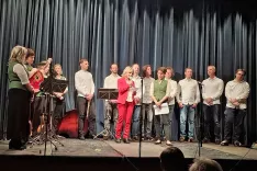 Slovenskemu prosvetnemu dru&scaron;tvu &Scaron;entjanž in predsednici Nadji Keuschnig je za jubilej čestitala tudi županja občine Bistrica v Rožu Sonya Feinig (v sredini). Za njima člani tambura&scaron;kega orkestra in pevci domačega pevskega zbora Andrej Permož. / Foto: Jože Ko&scaron;njek