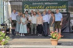 Organizatorji Kmečkega praznika, slovenski predstavniki v Koro&scaron;ki kmetijski zbornici, prejemniki priznanj na Ptuju in gostje na prireditvenem odru leto&scaron;njega praznika v &Scaron;entjanžu. Četrta z leve glavna organizatorka Marinka Mader Tschertou. / Foto: Jože Ko&scaron;njek