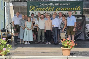 Organizatorji Kmečkega praznika, slovenski predstavniki v Koro&scaron;ki kmetijski zbornici, prejemniki priznanj na Ptuju in gostje na prireditvenem odru leto&scaron;njega praznika v &Scaron;entjanžu. Četrta z leve glavna organizatorka Marinka Mader Tschertou. / Foto: Jože Ko&scaron;njek
