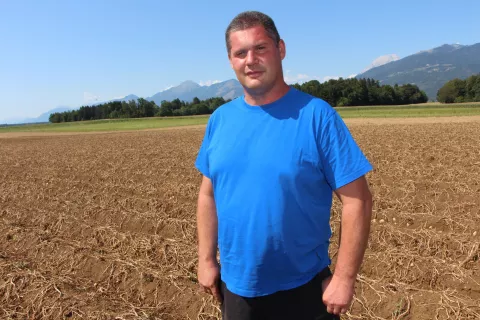 Marko Koritnik na polju, ki mu grozi načrtovana železnica / Foto: Cveto Zaplotnik