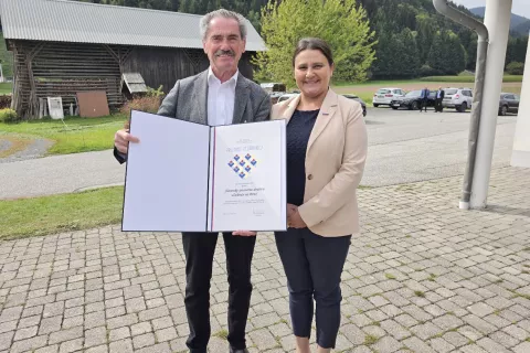 Blagajnik Slovenskega prosvetnega dru&scaron;tva Dobrač Hanzi Warum in ministrica Suzana Lep &Scaron;imenko s priznanjem, ki ga je podelila Dobraču za 120 &ndash; letnico delovanja. / Foto: Jože Ko&scaron;njek