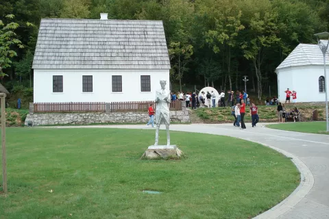 Teslina rojstna hiša v Smiljanu, desno pravoslavna cerkev, v kateri je bil za popa Nikolov oče Milutin. Hiša in cerkev sta bili med državljansko vojno 1995 požgani in nato obnovljeni. / Foto: Wikipedija