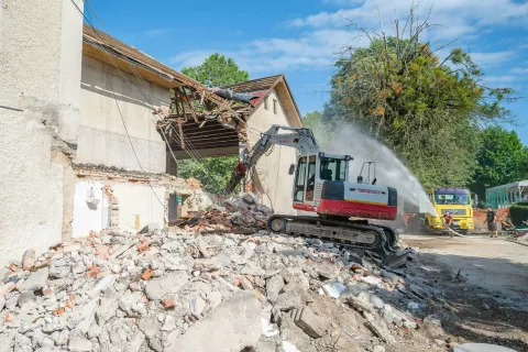 Stavbo nekdanjega telovadnega društva Partizan v Radovljici so konec tedna začeli rušiti. Kot so poudarili investitorji, so spominsko ploščo, ki je bila nameščena na pročelju, skrbno odstranili in poskrbeli za restavracijo, nato pa jo bodo umestili v kompleks novega objekta. / Foto: Nik Bertoncelj