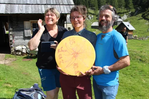 Na pogovoru o siru na planini Laz: (od leve) Irena Orešnik, Lucija Gartner in Milan Brence s 30 kilogramov težkim hlebom sira iz sirarne na Lazu / Foto: Cveto Zaplotnik