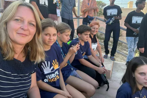 Učenci in Alenka Branc Demšar na srečanju z migranti. V ospredju ravnateljica Tanja Müller. / Foto: Arhiv šole