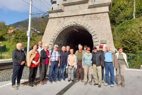 Udeleženci izleta v kraje, pomembne v boju za severno mejo v zahodnem delu Karavank, pred južnim portalom železni&scaron;kega predora na Hru&scaron;ici. Na severnem delu so leta 1918 in 1919 potekali hudi boji. / Foto: Jože Ko&scaron;njek