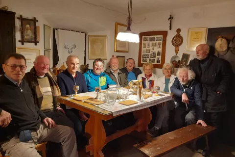 Udeleženci srečanja v hiši Šuštarjeve domačije. Levo je gostitelj Milan Krišelj. / Foto: Jože Košnjek