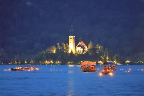 Na gladini blejskega jezera je zagorelo 15 tisoč lučk. / Foto: Miro Zalokar