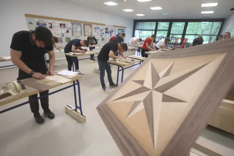 Dijaki pri izdelavi intarzije. / Foto: Gorazd Kavčič