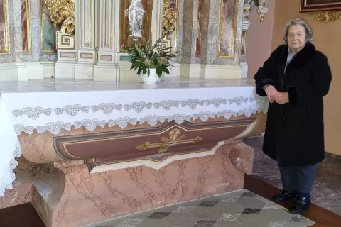 Julka Mohorič ob prtu, ki ga je naklekljala za stranski Marijin oltar župnijske cerkve v Železnikih / Foto: 