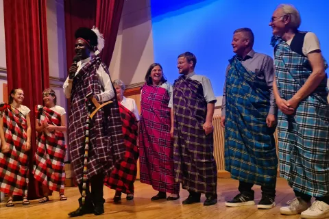 Ob koncu prireditve je, oblečen v tradicionalno opravo dežele, iz katere prizajaj, Imo Donaldsen, kenijska oblačila podaril tudi svojim gostiteljem v Gorjah: prostovoljkama Zali in Luciji, Jani Lampe iz Karitas Gorje, Mariji Orehar, tamkajšnjemu župniku Mateju Pavliču, županu Petru Torkarju in pevcu Aleksandru Mežku, ki je poskrbel za privlačen glasbeni del dobrodelne prireditve. / Foto:  