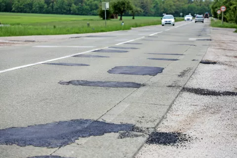 Na cesti od Jeprce proti Kranju so letos že izvedli nujna popravila vozišča, septembra pa naj bi začeli celovito prenovo dotrajanih odsekov. / Foto: Tina Dokl / Foto: 