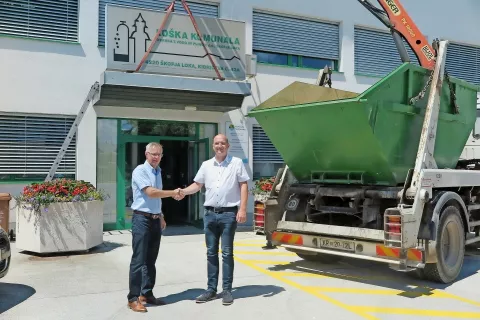 Ob odstranitvi table Loška komunala na stavbi na Kidričevi cesti sta si v roke segla v. d. direktorja Loške komunale Aleksander Kupljenik in direktor Javnega podjetja Komunala Škofja Loka Primož Ržen. / Foto: 