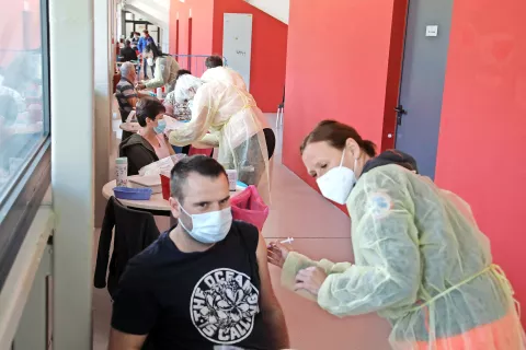 V jeseniški Športni dvorani Podmežakla so cepili na hodniku, organiziranih je bilo osem cepilnih mest, cepili so po 240 ljudi na uro. / Foto: Gorazd Kavčič / Foto: 