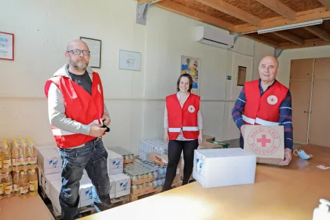 Prostovoljec Miha Sarnavsky, strokovna sodelavka Marjana Jugovec in vodja humanitarnega skladišča v Škofji Loki Metod Jamnik, ki je ob dnevu odprtih vrat obiskovalce seznanil z delom humanitarnega skladišča / Foto: Tina Dokl / Foto: 