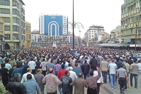 Vse skupaj se je začelo z velikimi, a mirnimi državljanskimi protesti. Na fotografiji je zborovanje proti Asadovemu režimu v Homsu 18. 4. 2011. / Foto: Wikipedija / Foto: 