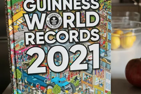Tudi naslovnico slovenske izdaje Guinnessove knjige rekordov 2021 krasi zanimiva ilustracija. / Foto: 