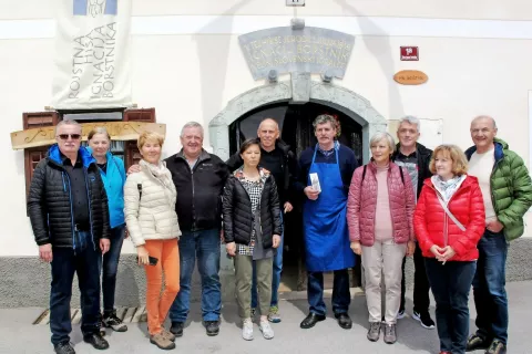 V Cerkljah so si kot prvi po epidemiji ogledali Borštnikovo domačijo. Sprejel jih je in jim izrekel dobrodošlico oskrbnik domačije Dane Novak (na sliki v sredini s predpasnikom). / Foto: 