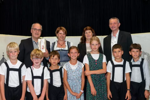 Župana Innichena in Železnikov Klaus Rainer (levo) in Anton Luznar s soprogama Karolino (druga z leve) in Majdo v družbi sori&scaron;kih otrok, ki so gostu predali vo&scaron;čeno svečo kot simbol večstoletnega povezovanja / Foto: Simon Benedičič