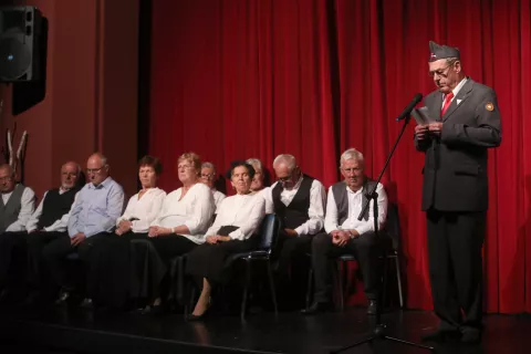 Osrednji govornik slovesnosti Vlado Bo&scaron;tar in MPZ Ljudski pevci Hi&scaron;e čez cesto Milje na odru Doma krajanov na Visokem / Foto: Gorazd Kavčič